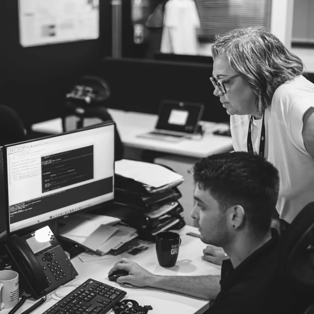 Net Defence team member working on a computer system with two monitors.