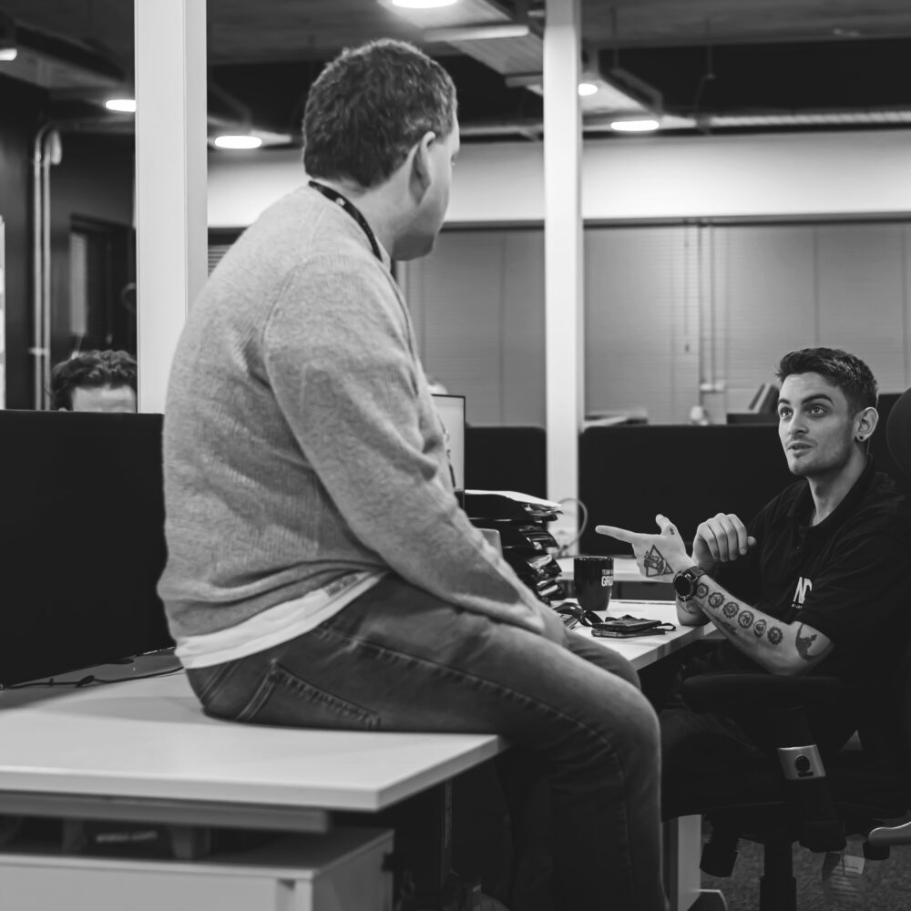 Two team members having a discussion in the Net-Defence office