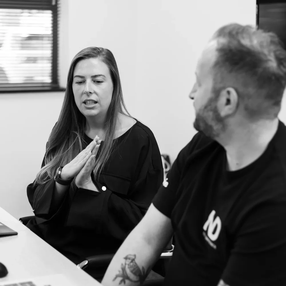 Two Net-defence colleagues talking in a meeting