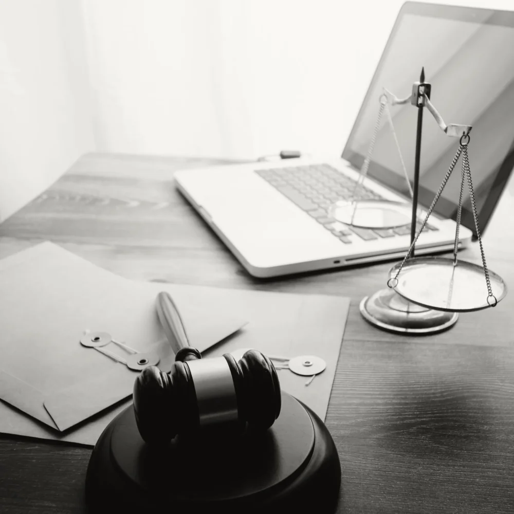 A solicitor's desk with a laptop, gavel, and scales.